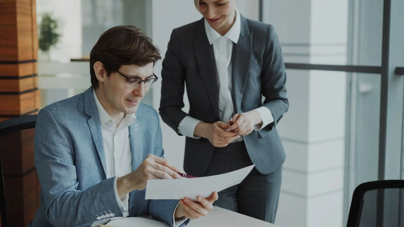 Two colleagues going through a document together in an office