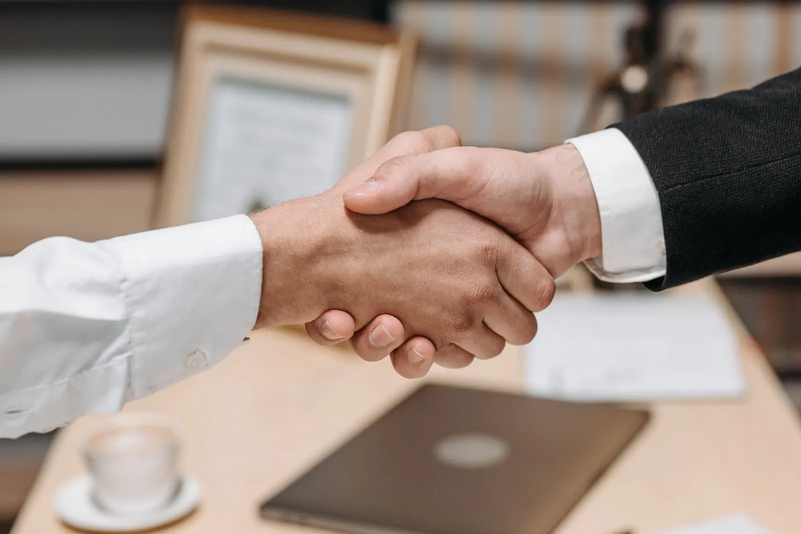 Two people shaking hands over a business investment agreement