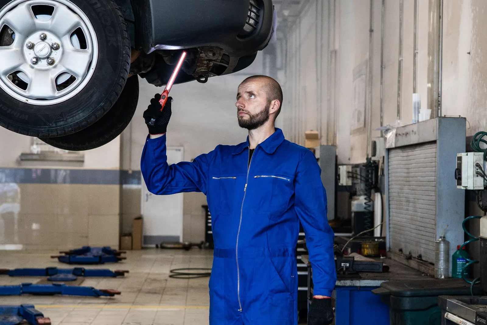 A mechanic working under a car in a garage
