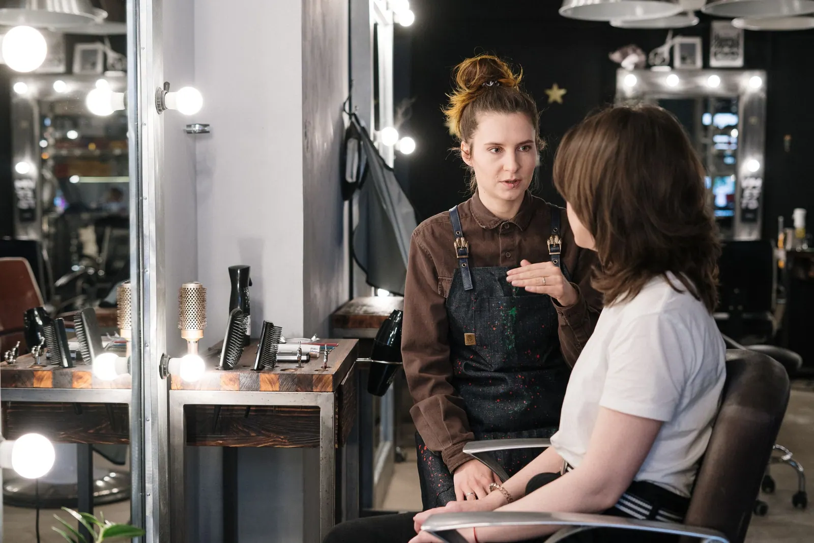 A hairdresser talking with a client in her salon