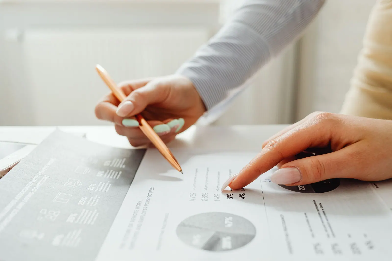 Two people going through a printed report together, one pointing at a figure