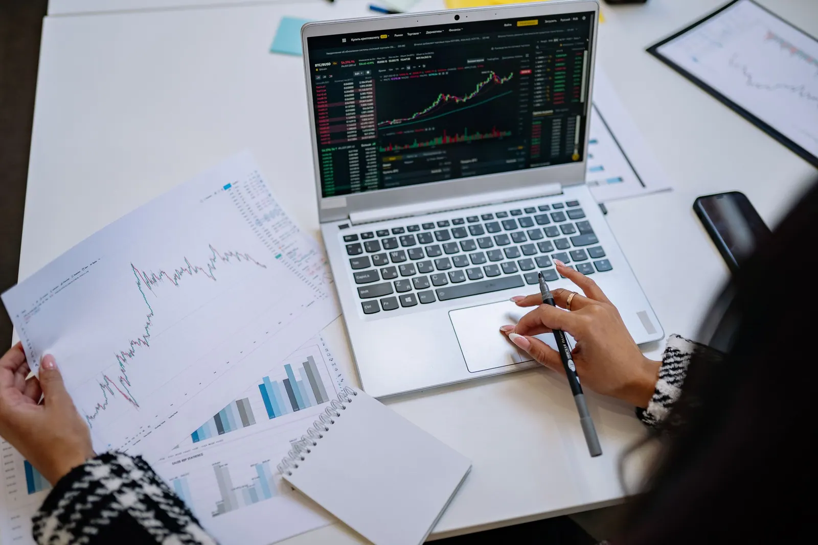 Monthly figures and charts on a laptop and on paper