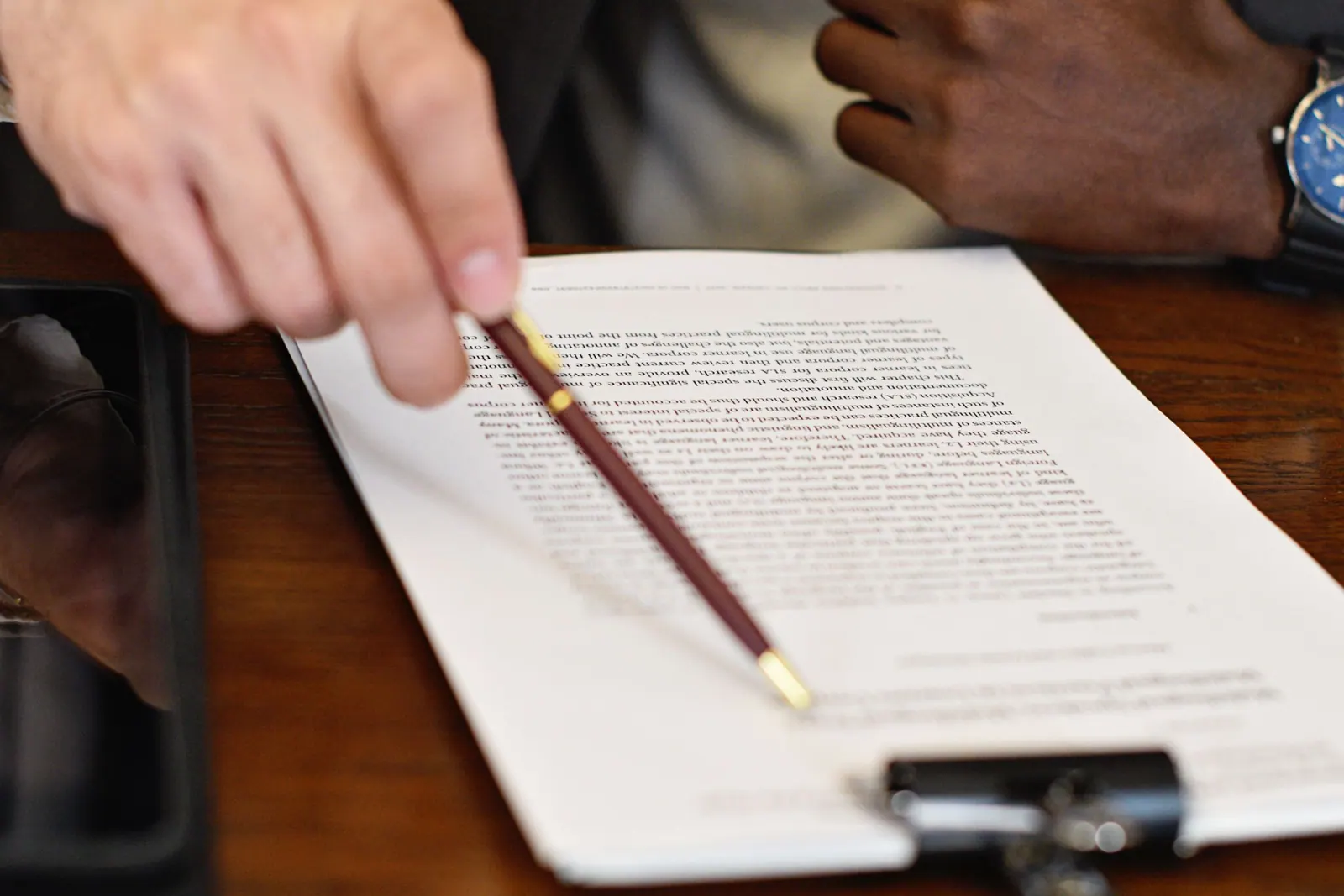 A contract being reviewed line by line with a pen